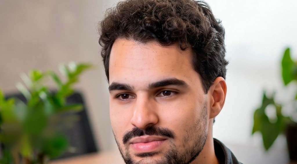Lucas de Oliveira no escritório, com plantas ao fundo